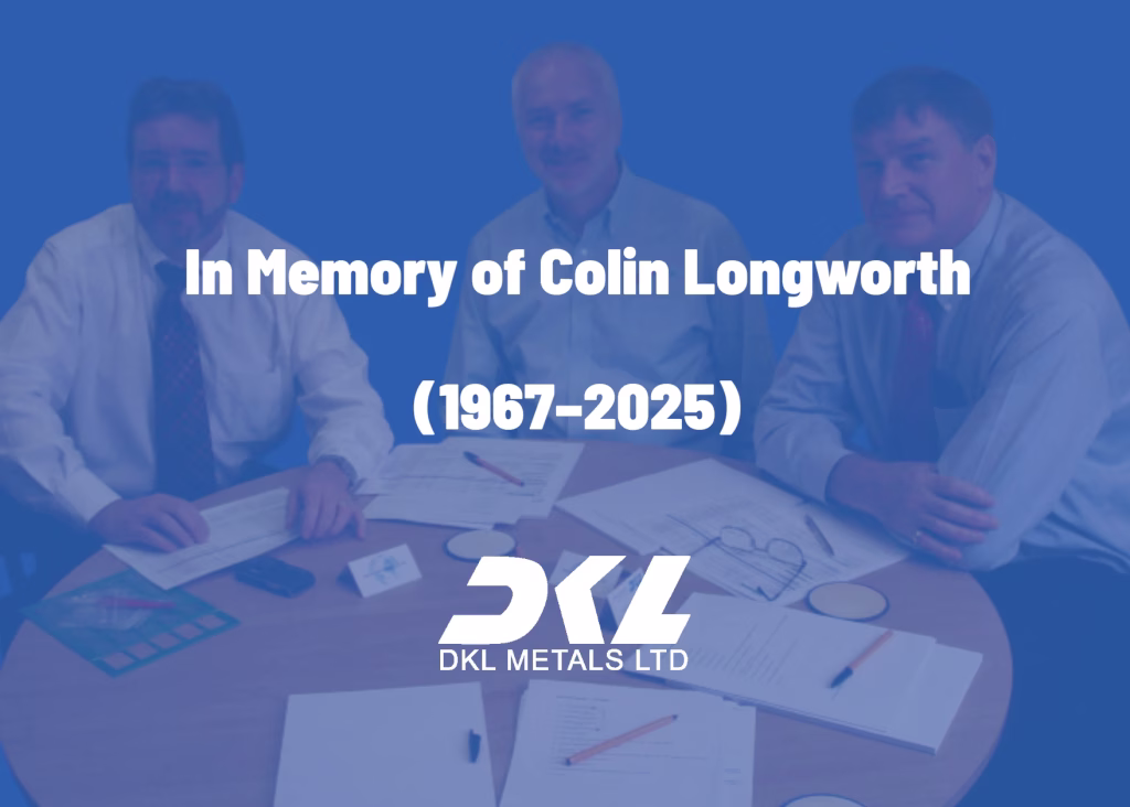 Colin Longworth sitting at a conference table, smiling and engaged in a meeting with several work colleagues faded with text overlayed